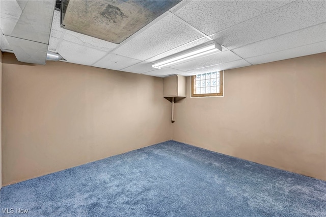 basement with carpet flooring and a paneled ceiling