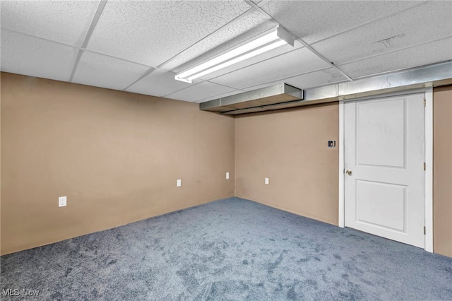 basement featuring a paneled ceiling and carpet floors