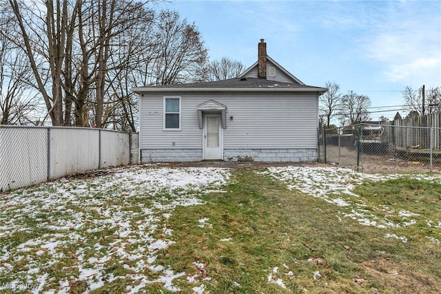 snow covered back of property with a lawn