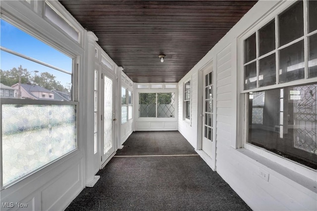 unfurnished sunroom featuring wooden ceiling and a healthy amount of sunlight