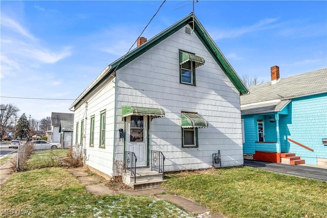 rear view of property featuring a lawn