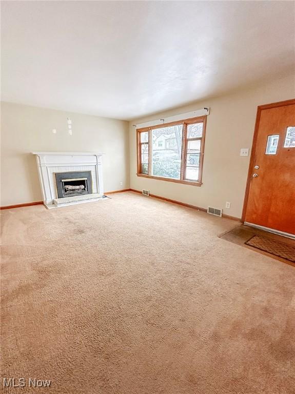 unfurnished living room with light colored carpet