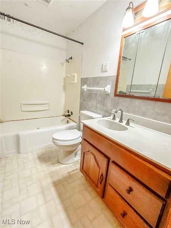 full bathroom with vanity,  shower combination, toilet, and tile walls