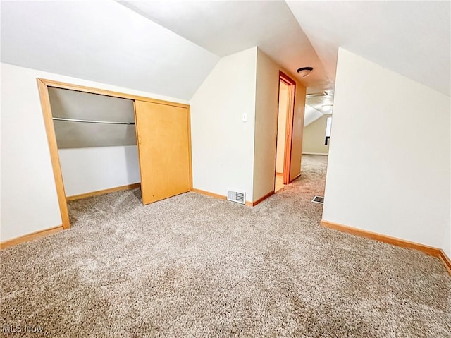 additional living space with carpet flooring and lofted ceiling