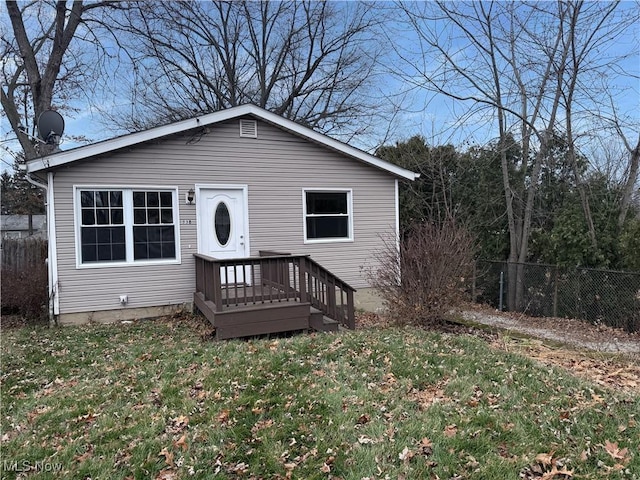 view of front of home with a front yard and a wooden deck