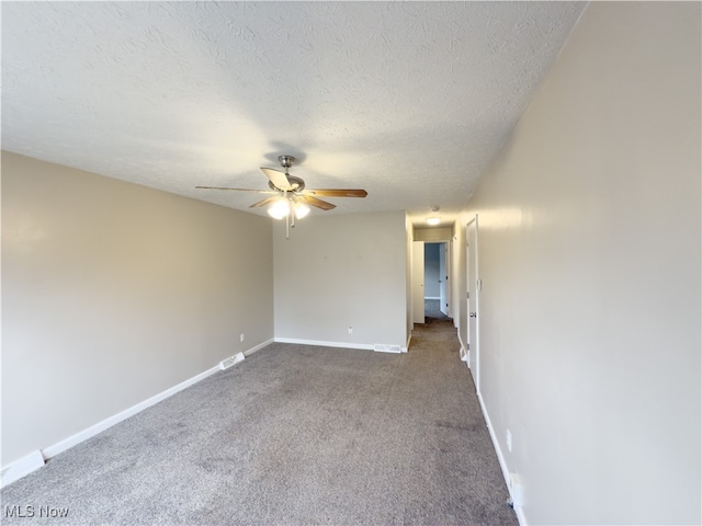 carpeted empty room featuring ceiling fan and a textured ceiling