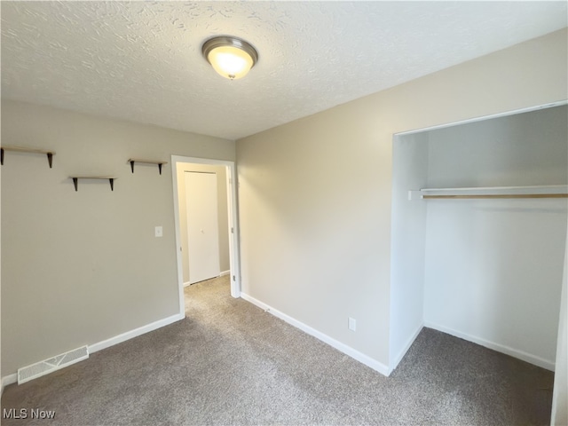 unfurnished bedroom featuring carpet flooring, a textured ceiling, and a closet