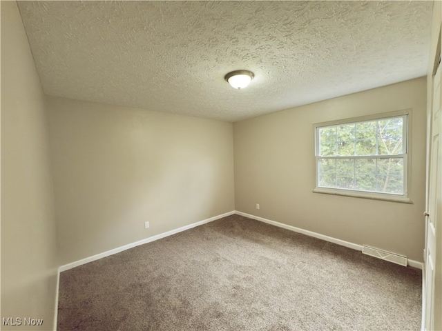 carpeted spare room with a textured ceiling