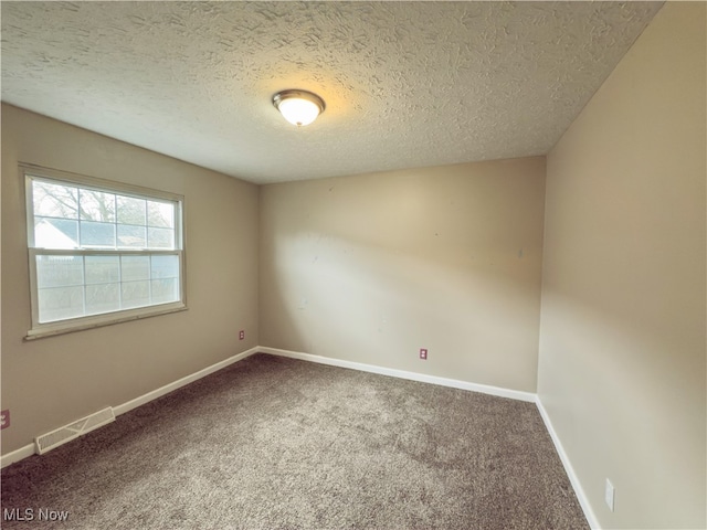 empty room featuring carpet and a textured ceiling