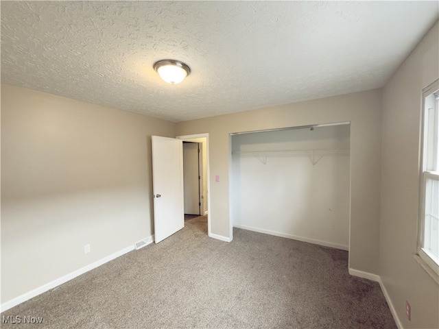 unfurnished bedroom featuring carpet flooring, a textured ceiling, and a closet