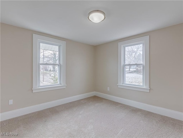 spare room featuring carpet flooring and plenty of natural light