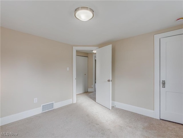 unfurnished room featuring light carpet