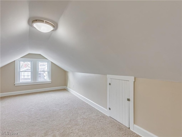 bonus room featuring light colored carpet and vaulted ceiling