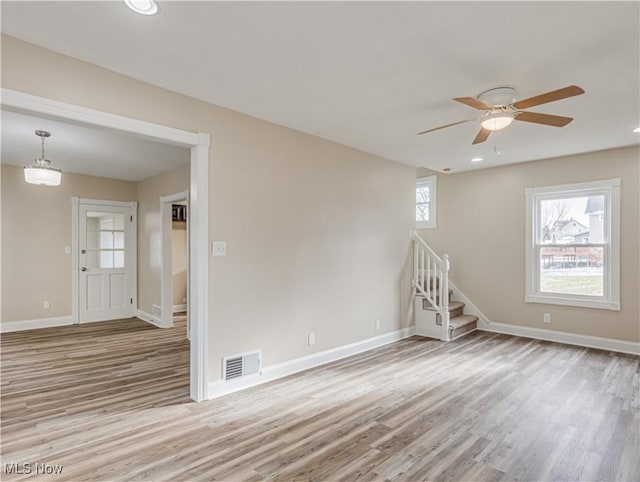 unfurnished room with ceiling fan, a wealth of natural light, and light hardwood / wood-style flooring