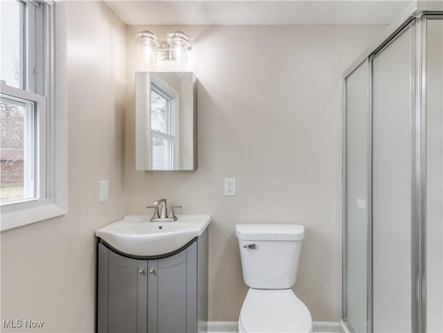 bathroom with vanity, toilet, and a shower with shower door