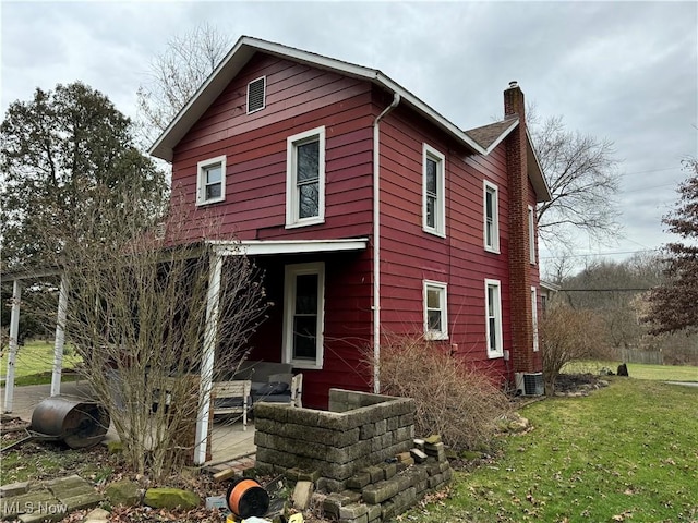 back of house with a yard and central air condition unit