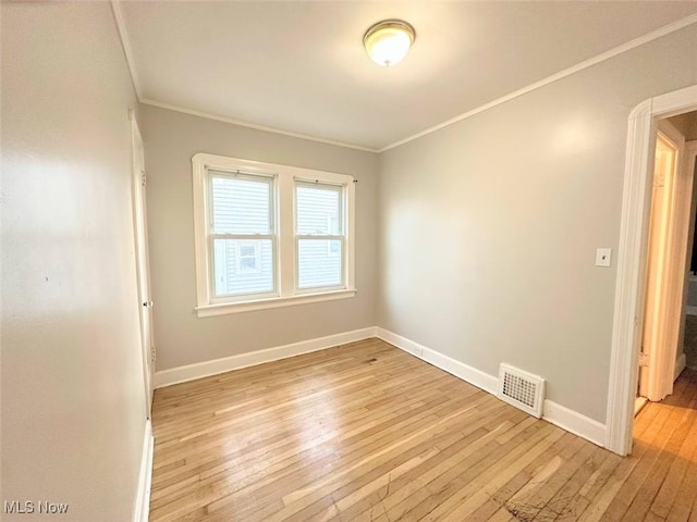 spare room with light hardwood / wood-style floors and crown molding