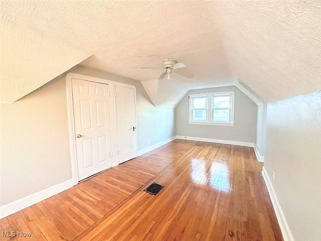 bonus room featuring hardwood / wood-style flooring, ceiling fan, and a textured ceiling