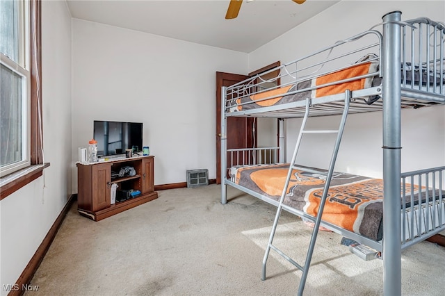 carpeted bedroom with multiple windows and ceiling fan