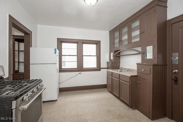 kitchen with stainless steel range, white fridge, and sink