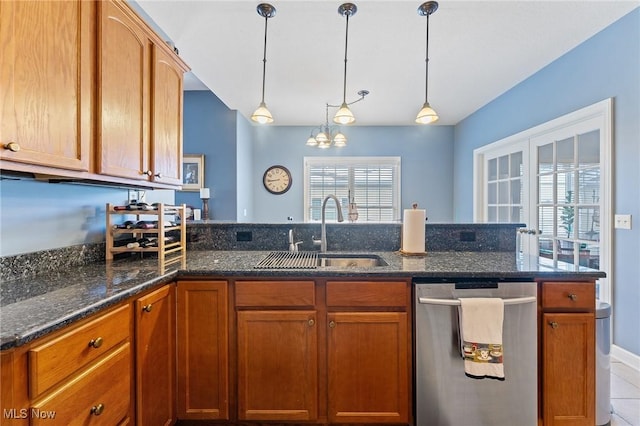 kitchen with dark stone counters, an inviting chandelier, sink, stainless steel dishwasher, and decorative light fixtures