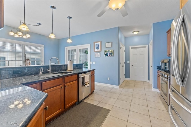 kitchen featuring ceiling fan, sink, stainless steel appliances, pendant lighting, and light tile patterned floors