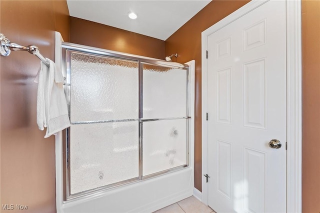 bathroom featuring tile patterned flooring and bath / shower combo with glass door