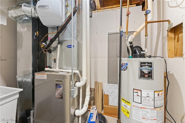 utility room featuring heating unit, water heater, and sink