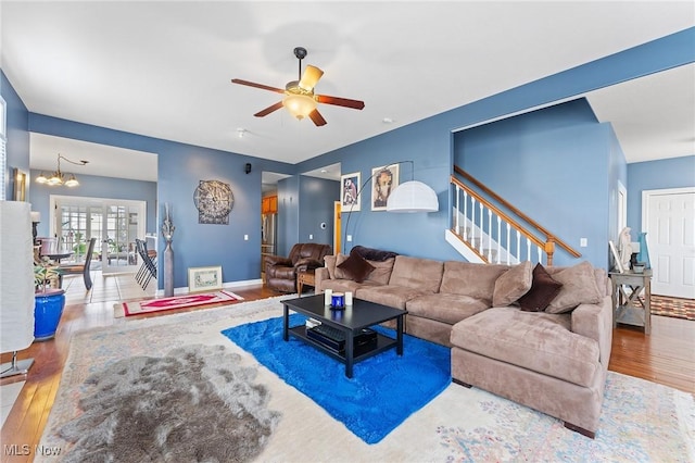 living room featuring hardwood / wood-style floors and ceiling fan with notable chandelier