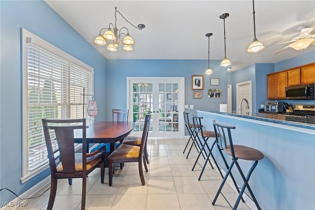 tiled dining area featuring french doors, ceiling fan with notable chandelier, and sink