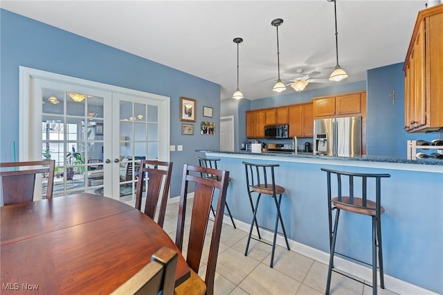 kitchen with french doors, hanging light fixtures, ceiling fan, stainless steel fridge, and light tile patterned floors