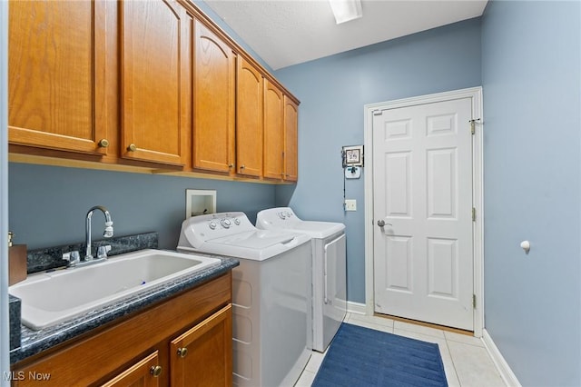 laundry area featuring light tile patterned flooring, cabinets, independent washer and dryer, and sink