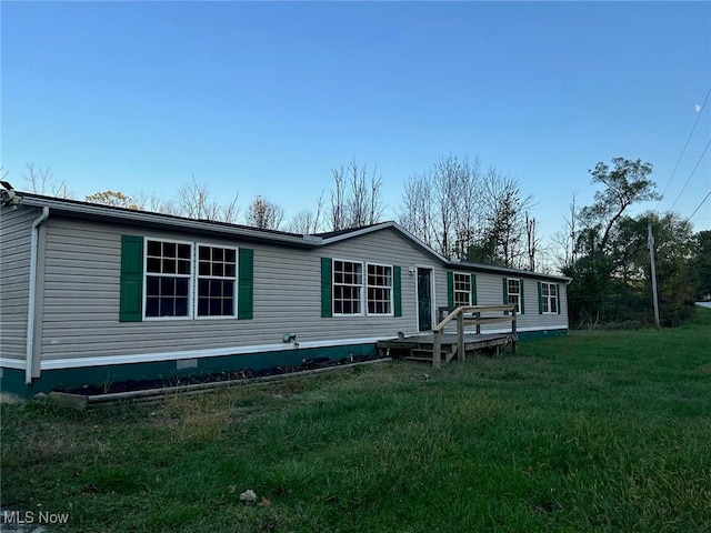 back of property featuring a lawn and a wooden deck