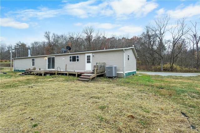 back of house with a yard, a wooden deck, and central air condition unit