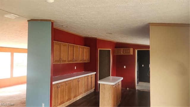 kitchen with a textured ceiling, a center island, dark carpet, and lofted ceiling