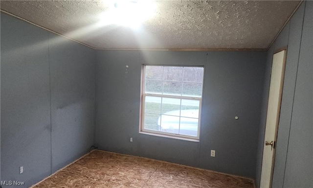 empty room with a textured ceiling and vaulted ceiling