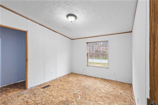 unfurnished bedroom featuring ornamental molding and a textured ceiling