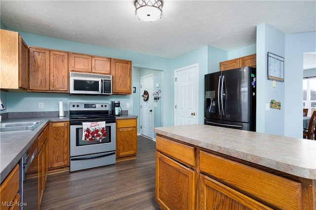 kitchen featuring dark hardwood / wood-style flooring, sink, black appliances, and a textured ceiling