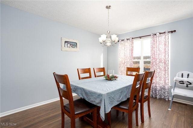 dining space featuring a textured ceiling, a chandelier, and dark hardwood / wood-style floors