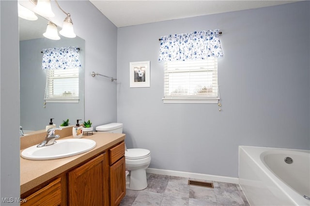 bathroom featuring vanity, a bath, and toilet