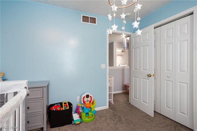 carpeted bedroom with a textured ceiling, an inviting chandelier, and a closet