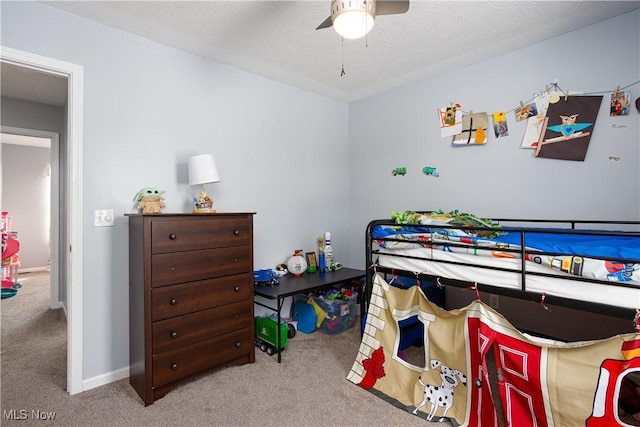 bedroom featuring ceiling fan, light colored carpet, and a textured ceiling