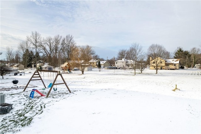 yard layered in snow featuring a playground