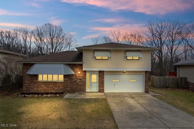 split level home with a garage and a yard