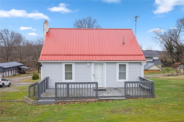 rear view of house featuring a yard and a deck