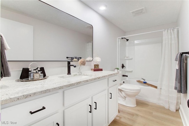 full bathroom featuring toilet, hardwood / wood-style floors, vanity, and shower / tub combo with curtain