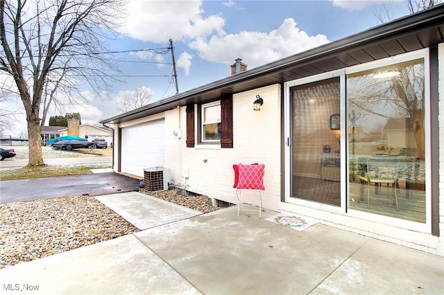 property entrance with cooling unit and a garage