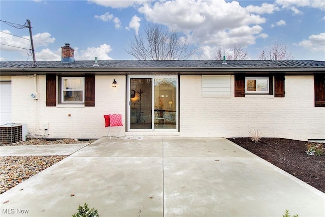 back of property with central air condition unit and a patio area