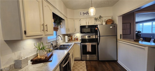 kitchen featuring tasteful backsplash, stainless steel appliances, sink, pendant lighting, and white cabinets