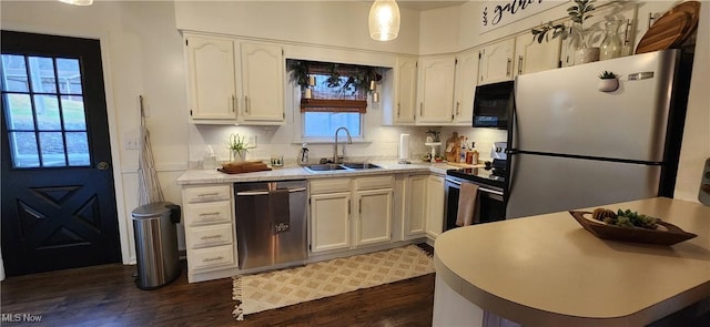 kitchen featuring sink, dark hardwood / wood-style flooring, pendant lighting, white cabinets, and appliances with stainless steel finishes